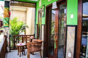 a balcony with a table and chairs on a building at Reynold Artha Guest House in Nusa Lembongan +1 photo
