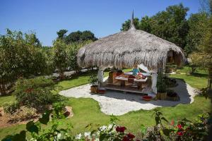 a woman sitting in a hut in a garden at Bluewater Panglao Beach Resort in Panglao Island