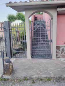 an entrance to a pink house with an iron gate at Benvenuti a casa in Certaldo +2 photos