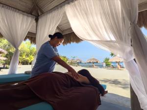 a woman getting a massage at the beach at Bluewater Panglao Beach Resort in Panglao Island