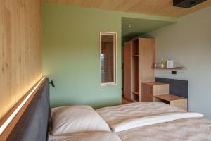 a bedroom with a bed and a green wall at Schlafgut am Johanneshof in Tattendorf