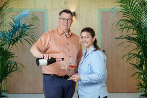 a man and a woman holding glasses of wine at Schlafgut am Johanneshof in Tattendorf