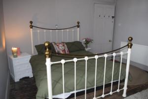 a bedroom with a bed with a white bed frame at Gorffwysfa Hideaway Double 1st floor in Pwllheli