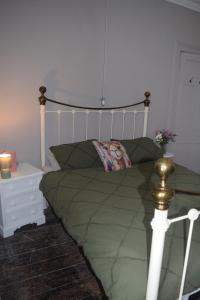 a bedroom with a bed with a green comforter at Gorffwysfa Hideaway Double 1st floor in Pwllheli