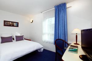 a hotel room with a bed and a window at Appart'City Classic Clermont Ferrand Centre in Clermont-Ferrand