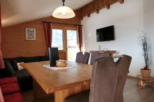 a dining room with a wooden table and chairs at Ferienhaus Wöscher in Kaltenbach