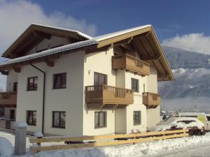 a building in the snow with a balcony at Ferienhaus Wöscher in Kaltenbach