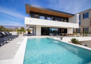 a house with a swimming pool in front of it at Villa Solis in Novalja