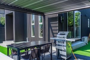a screened in porch with a table and a stove at Galaxy Pool Resort in Takashima