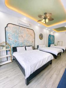 a bedroom with two beds and a painting on the wall at Victoria Villa 2 in Hue
