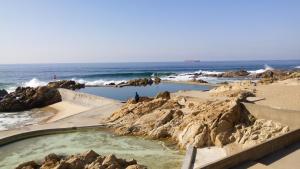 a hot tub on the beach next to the ocean at VRS - Low Cost Beach Boat in Leça da Palmeira