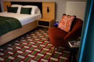 a small bedroom with a bed and a chair at Apartament Centrum z tarasem prywatny parking in Płock