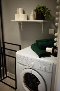 a washing machine with green towels on top of it at Apartament Centrum z tarasem prywatny parking in Płock