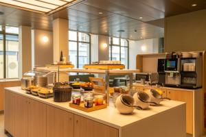 a kitchen with a counter with food on it at Hôtel le Square in Geneva