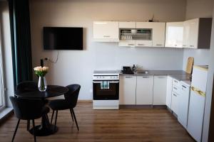 a small kitchen with a table and a kitchen with white cabinets at Apartament Centrum z tarasem prywatny parking in Płock