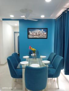 a dining room with blue walls and a table and blue chairs at Coco Villa with Private Pool in Karjat