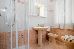 a bathroom with a sink and a shower and a toilet at Hotel Milena in Cervia