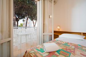 a bedroom with a bed and a balcony at Hotel Milena in Cervia