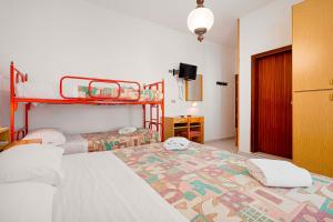 a bedroom with two bunk beds and a television at Hotel Milena in Cervia +10 photos