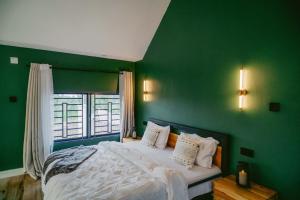 a green bedroom with a bed and a window at Starico Residence in Nkoanrua