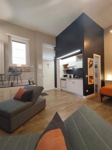 a living room with a couch and a kitchen at Loft 18A Roma - Casa con ingresso indipendente e parcheggio gratuito in Rome