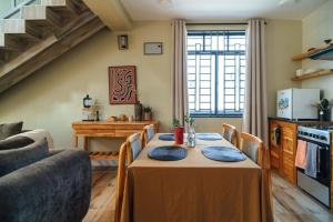 a dining room with a table with blue pillows on it at Starico Residence in Nkoanrua