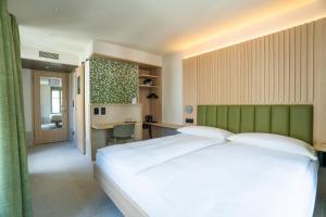 a bedroom with a large white bed and a desk at Hôtel le Square in Geneva +12 photos