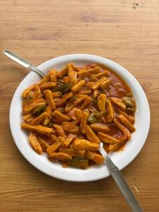 a bowl of pasta with sauce and green peppers at Blue Heaven Tosh in Tosh