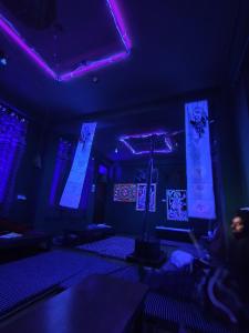 a dark room with purple lights and a stage at Blue Heaven Tosh in Tosh