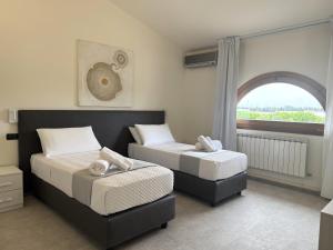 two beds in a room with a window at Ferrocino Resort in Galatone +129 photos