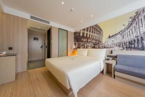 a bedroom with a large white bed and a blue couch at 亚轻x酒店上海同济医院新村路地铁站店 in Shanghai