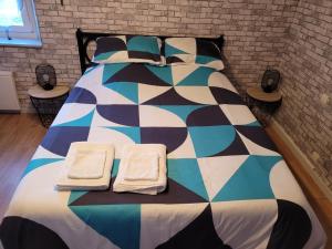 a large bed with two towels on top of it at le lieu jeanne in Auvers