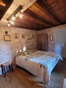 a bedroom with a bed in a room with wooden ceilings at le lieu jeanne in Auvers