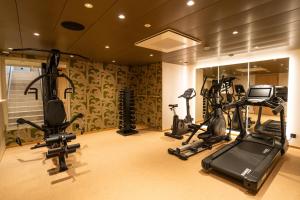 a gym with several exercise bikes in a room at Hôtel le Square in Geneva
