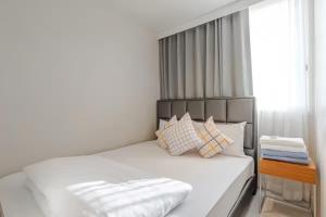 a bedroom with a white bed with a headboard and pillows at Veranda Residence Pattaya in Na Jomtien