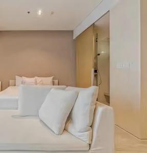 a bedroom with a white bed with white pillows at Veranda Residence Pattaya in Na Jomtien
