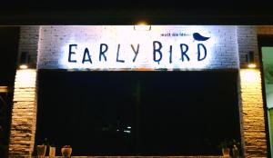 a sign that says early bird on a brick wall at Early Bird Hostel Ayutthaya in Phra Nakhon Si Ayutthaya