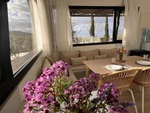 a living room with a table and purple flowers at Finca Jardín del Norte in Gáldar