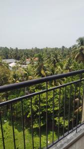 a balcony with a view of a bunch of palm trees at Krishna vykundam guruvayur in Guruvāyūr +15 photos