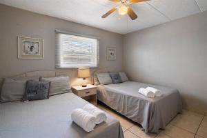 a bedroom with two beds and a ceiling fan at Oceanfront Condo w Heated Pool & Reserved Parking in Wildwood Crest +8 photos