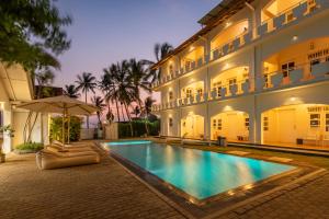 a swimming pool in front of a building at Shangrela Beach Resort by ARK in Ambalangoda
