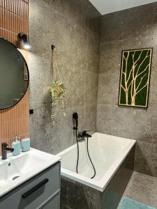 a bathroom with a sink and a bath tub at Studio 102 Garden in Krakow