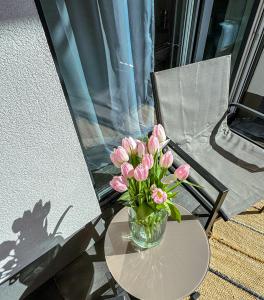a vase of pink flowers sitting on a table at Studio 102 Garden in Krakow