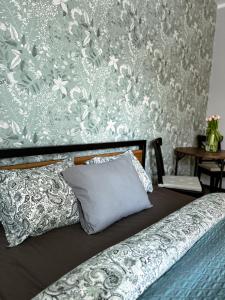 a bed with a pillow and a floral wall at Studio 102 Garden in Krakow