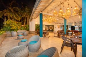 a restaurant with tables and chairs and lights at Shangrela Beach Resort by ARK in Ambalangoda