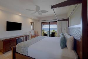 a bedroom with a bed and a flat screen tv at Catalonia Yucatan Beach - All Inclusive in Puerto Aventuras
