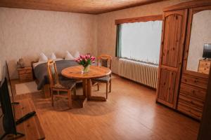 a bedroom with a table and a bed and a table and chairs at Erzhof Nassau- Gästezimmer an der Loipe in Bienenmühle