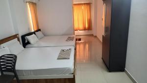 a small room with two beds and a hallway at Krishna vykundam guruvayur in Guruvāyūr