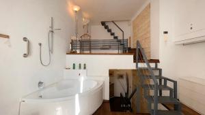 a large white tub in a bathroom with a staircase at La Baita nel Borgo HOWME in Bari +30 photos