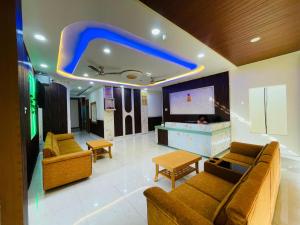 a living room with two couches and a flat screen tv at Executives palace in Rāmgarh